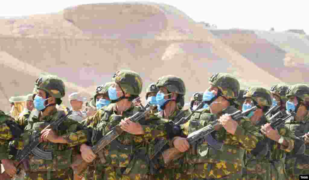 Soldiers march in face masks.