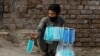 FILE: A man sells protective masks outside a cattle market in the northwestern city of Peshawar in July.