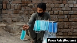 FILE: A man sells protective masks outside a cattle market in the northwestern city of Peshawar in July.