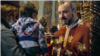 Priest in an Orthodox Church in Romania gives the Holy Communion to a child