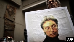 A man holds a portrait of slain Russian journalist Anna Politkovskaya during a rally marking the eighth anniversary of her death in Moscow on October 7, 2014.