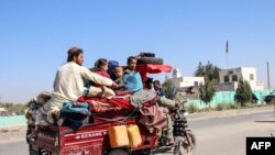 Internally displaced people flee from Lashkar Gah during the ongoing clashes between Taliban fighters and Afghan security forces on October 14.