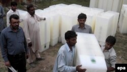 Workers at the election commission office in Lahore sort ballot boxes for Pakistan's upcoming general election.