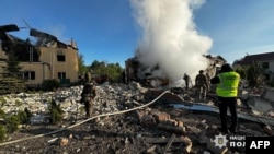 Співробітники Державної служби з надзвичайних ситуацій гасять пожежі приватних будинків, зруйнованих обстрілом у Харкові, 10 травня 2024 року