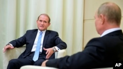 Ukrainian tycoon Viktor Medvedchuk (left) speaks with Russian President Vladimir Putin during a meeting at the Novo-Ogaryovo residence outside Moscow in 2020.