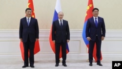 Chinese leader Xi Jinping, Russian President Vladimir Putin, and Mongolian President Ukhnaa Khurelsukh pose for a photo at the Shanghai Cooperation Organization summit in Uzbekistan in 2022.