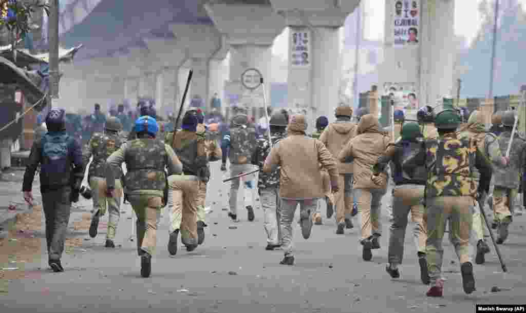 Policemen chase protesters during a protest in the Seelampur area of New Delhi on December 17.