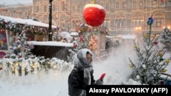 Një grua ec pranë tezgave të tregut në Sheshin e Kuq të mbuluar me borë në Moskë, 3 dhjetor 2023.
