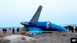 A section of an Azerbaijan Airlines Embraer 190 aircraft lies on the ground near the airport of Aktau, Kazakhstan, on December 26.