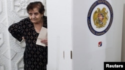 A voter holds a ballot at a polling station during a parliamentary election in Yerevan.