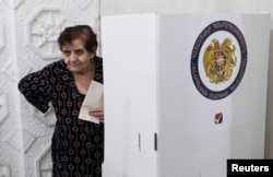 Виборчиня тримає бюлетень на виборчій дільниці в Єревані