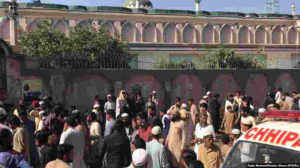 People gather in front of the Islamic seminary.