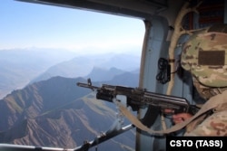 Участник операции Организация Договора о коллективной безопасности (ОДКБ) осматривает территорию у таджикско-афганской границы.