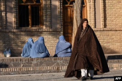 Gra afgane të veshura me burka ulen në trotuar në zonën Gazargah të Heratit, më 7 janar 2026.