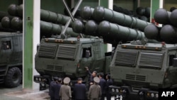 Kjo fotografi, e realizuar në datë të paspecifikuar mes 16 e 18 shtatorit 2026, e publikuar nga KCNA më 19 shtator 2026, shfaq liderin e Koresë së Veriut, Kim Jong Un (i treti nga e djathta), duke inspektuar një fabrikë municionesh në një lokacion të pazbuluar në Korenë e Veriut.