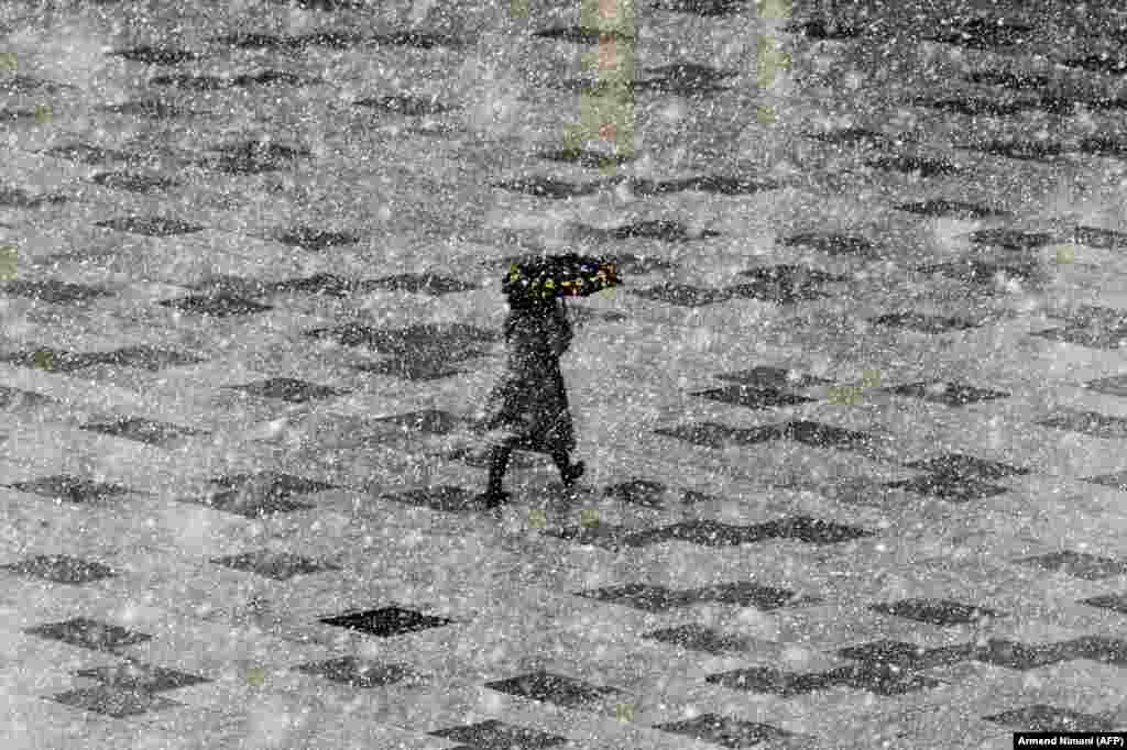 A pedestrian walks through Mother Teresa Square during a heavy snowfall in the Kosovar town of Pristina. (AFP/Armend Nimani)