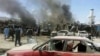 Afghan security personnel are pictured past mangled cars at the scene of a suicide attack at a busy market in Urgun district, Paktika Province, on July 15. 