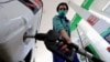 A gas-station attendant fills a car in Peshawar.