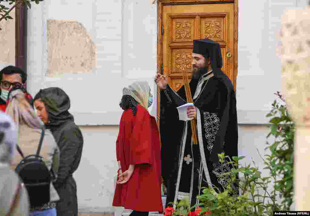 O credincioasă vorbește cu un preot &#238;n timpul slujbei religioase din Vinerea Mare, la Mănăstirea Radu Vodă din București, Rom&#226;nia.