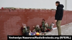 Люди несуть квіти, іграшки та свічки на меморіал біля місця ракетного удару 14 січня 2023 року