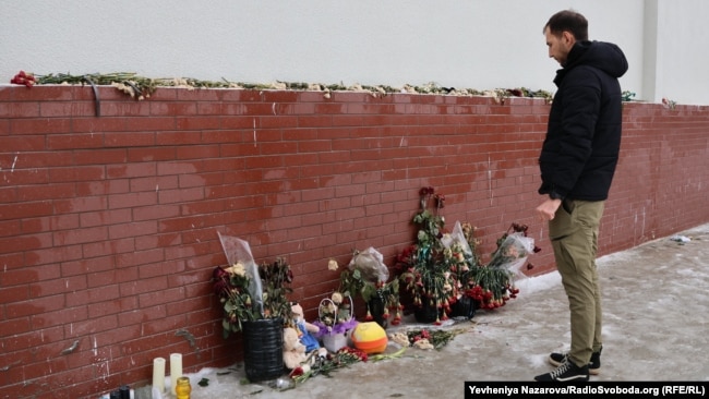 Люди несуть квіти, іграшки та свічки на меморіал біля місця ракетного удару 14 січня 2023 року