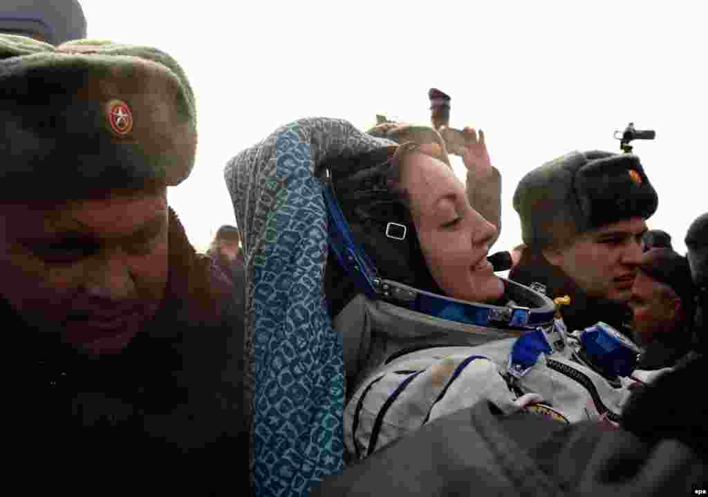 Russia&#39;s space agency ground personnel help cosmonaut Yelena Serova after landing.