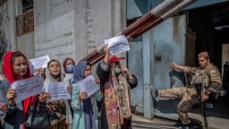 Tálib harcos figyeli a jogaikat követelő nőket egy kabuli tüntetésen, az egykori Nőügyi Minisztérium előtt. 2021. szeptember 19. 