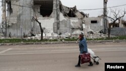 A local resident walks past a destroyed building in Mariupol on April 19. 