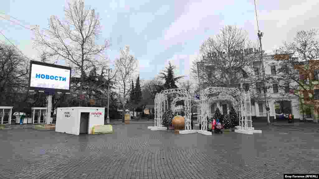 Новогодние инсталляции на площади Нахимова в Севастополе и пропагандистский экран с новостями «русского мира»