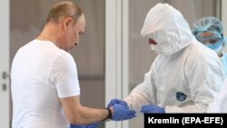 Президент России Владимир Путин (слева) во время посещения больницы для пациентов с коронавирусной инфекцией в Москве (архивное фото)