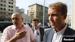 BP Russia President Jeremy Huck (right) speaks to the media as he leaves an office building in Moscow on August 31.