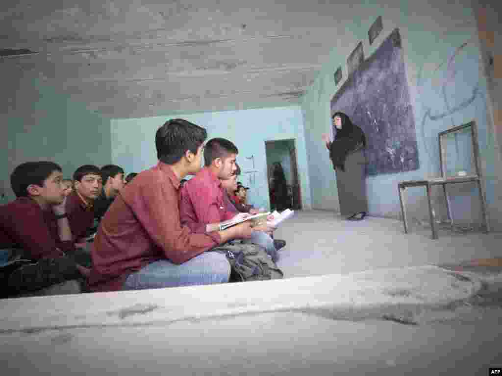 Afghan students sit on the floor during a lesson at the Nasoana school in Kabul.