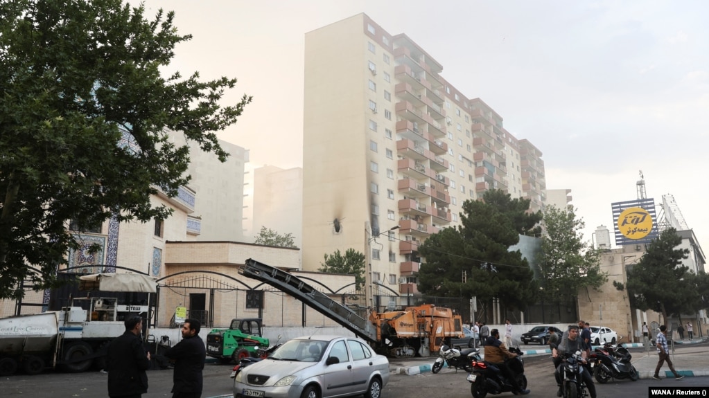 Mọi người tụ tập quanh một tòa nhà bị hư hại sau cuộc không kích của Israel vào Tehran.