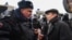 Russian human rights activist Lev Ponomaryov (right) speaks with a police officer during a rally in front of the FSB headquarters in central Moscow on March 14.