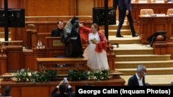 Diana Șoșoaca, în Parlament, ducând un sac de gunoi premierului de la acea vreme, Florin Cîțu. 