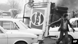 IRAN -- file -- In this Dec. 27, 1978 file picture, an overturned truck with a Pepsi soft drink logo burns in the center of Tehran during riots which paralyzed the city. The popular revolt against the shah raised alarm bells in the West, which saw the sh