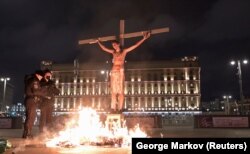 Pavel Krisevich stages a crucifixion performance in support of political prisoners near the headquarters of Russia's Federal Security Service (FSB) in Moscow on November 2020.