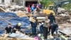 Rescue workers and locals in the village of Glogosnica begin cleaning up on October 5, a day after deadly floods and landslides in southern Bosnia. 