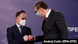 Serbian President Aleksandar Vucic (right) and German Foreign Minister Heiko Maas fist-bump after their meeting in Belgrade on April 23.