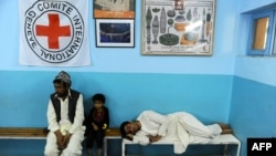 patients wait on a benches at the International Committee of Red Cross ( ICRC) hospital for war victims in Herat province, August 17, 2014.