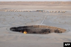 Flames inside the crater, with a backdrop of tourist yurts, photographed in June. The site has been equipped with helipads and its own guesthouse.