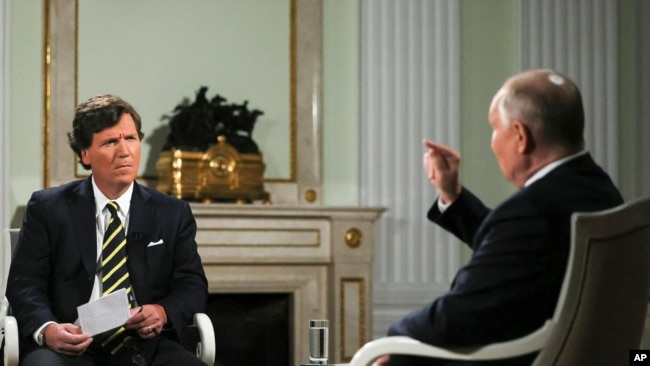 Президент России Владимир Путин (справа) во время интервью с бывшим ведущим Fox News Такером Карлсоном в Кремле. Москва, 2 февраля 2024 года