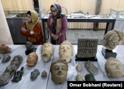 Museum workers stand next to artifacts that were smuggled to the United States andt then returned to the National Museum in Kabul in April 2021.