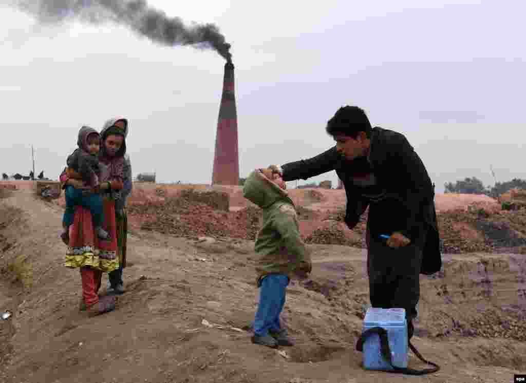 A health worker administers a polio vaccine to a child in Jalalabad, Afghanistan. Afghanistan is one of the two countries, along with neighboring Pakistan, where polio is still endemic, crippling hundreds of children every year. (epa/Ghulamullah Habibi)