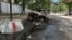 Випалена російським дроном цивільна автівка у Херсоні на тлі антидронових сіток (архівне фото)