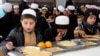 Afghan orphans, who lost their parents in fighting, eat a meal at Sheikh Mohammed Bin Rashid al-Maktoum orphanage house in the southern city of Kandahar on February 20.