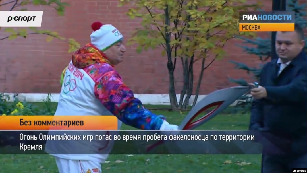 Russian Olympic torchbearer Shavarsh Karapetyan gets help relighting the torch after it flickered out at the Kremlin in Moscow on October 6.