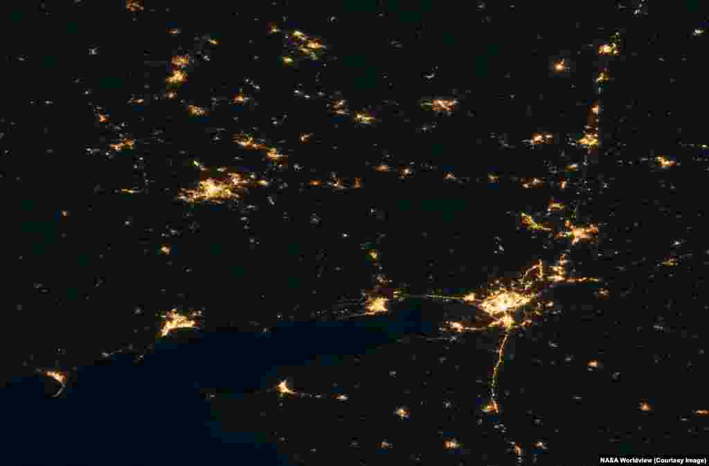 Ukraine's Donetsk Region, taking up roughly the left third of this image, and part of the Luhansk region (upper center) are seen next to Russia's Rostov region (right). The nighttime pictures were made on October 26, 2021, and July 1, 2026.Several towns in the top left of the historic image, which lie in Ukraine's Donetsk region, have fallen dark, while the bright lights of Russian-occupied Donetsk (upper left) remain largely unchanged. South of Donetsk, the now Russian-held city of Mariupol is visible at lower left of the image. Russia's Rostov-on-Don is the large city seen at lower right.
