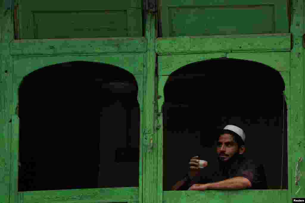 A man drinks a cup of green tea in a tea shop in Peshawar, Pakistan.