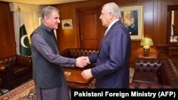 Pakistani Foreign Minister Shah Mahmood Qureshi (left) greets U.S. Special Representative for Afghanistan Zalmay Khalilzad in Islamabad on April 5. 